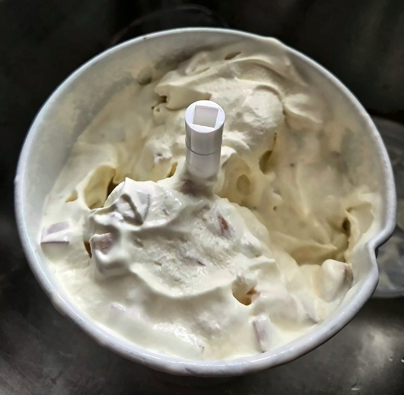 Freshly hand-churned ice cream with fruit pieces, straight from the churn